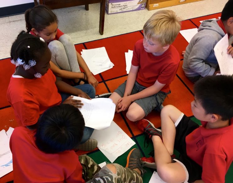 Students sitting in circle talking about writing