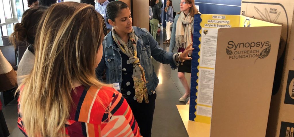 three women looking at a poster