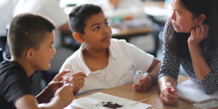 TWO STUDENTS talking with a teacher